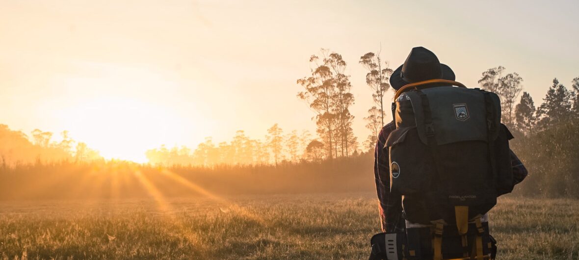 man in black backpack during golden hour